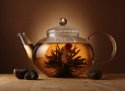 glass teapot with blooming herbal flower